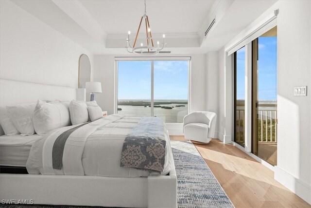 4951 Bonita Bay Blvd Unit 2205, Bonita Springs, FL 34134 - bedroom featuring a chandelier, crown molding, wood finished floors, and a raised ceiling