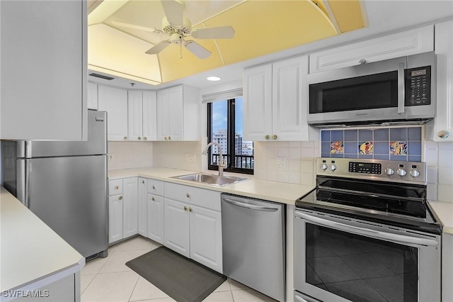 kitchen featuring a sink, stainless steel appliances, white cabinets, and light countertops