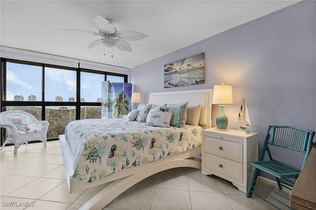 bedroom featuring ceiling fan, light tile patterned floors, and expansive windows