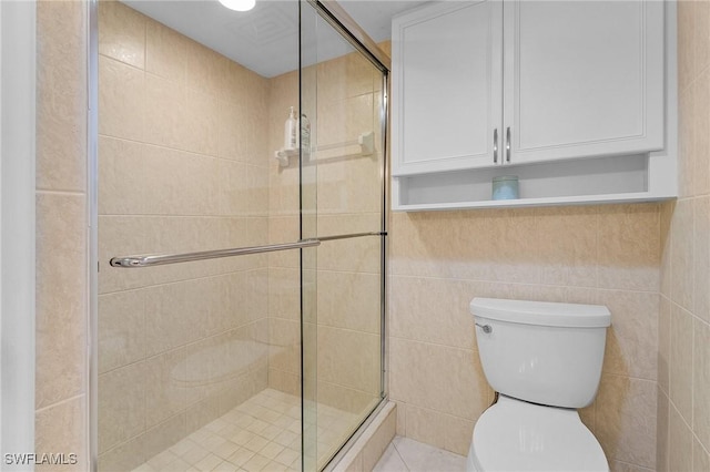 full bathroom with a shower stall, toilet, and tile walls