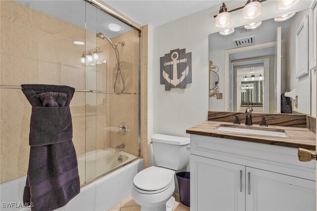 full bath with vanity, toilet, visible vents, and bath / shower combo with glass door