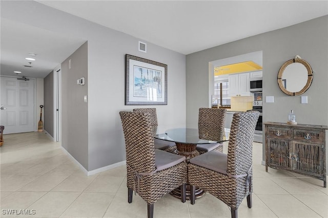 dining space featuring light tile patterned floors, baseboards, and visible vents