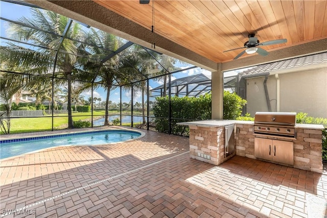 view of pool featuring glass enclosure, ceiling fan, exterior kitchen, grilling area, and a patio area