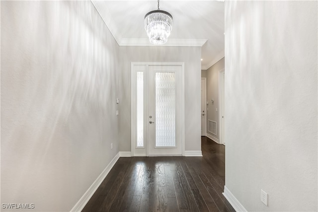 entrance foyer with dark hardwood / wood-style flooring, crown molding, and an inviting chandelier