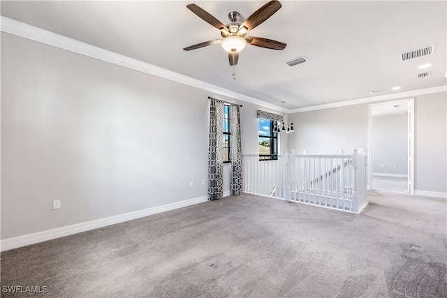 empty room with ceiling fan, carpet floors, and crown molding