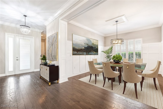 dining space featuring dark hardwood / wood-style floors, an inviting chandelier, and crown molding