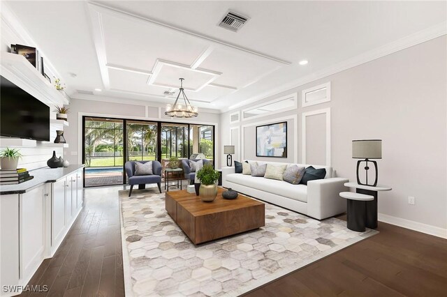 living room with wood-type flooring, an inviting chandelier, and ornamental molding