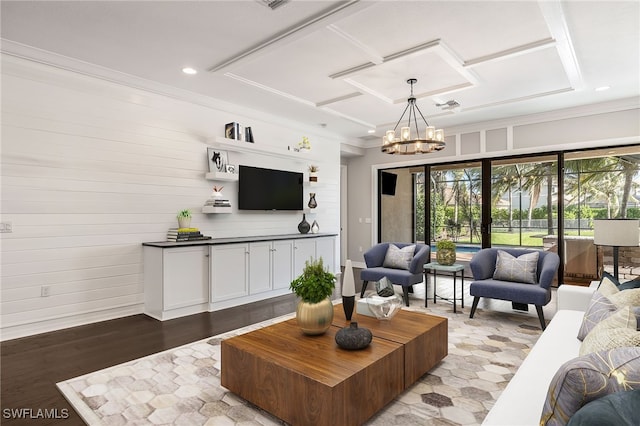 living room with light wood-type flooring, crown molding, and an inviting chandelier