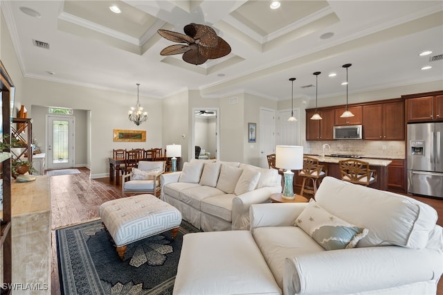 living room featuring coffered ceiling, beamed ceiling, dark hardwood / wood-style floors, ceiling fan with notable chandelier, and ornamental molding