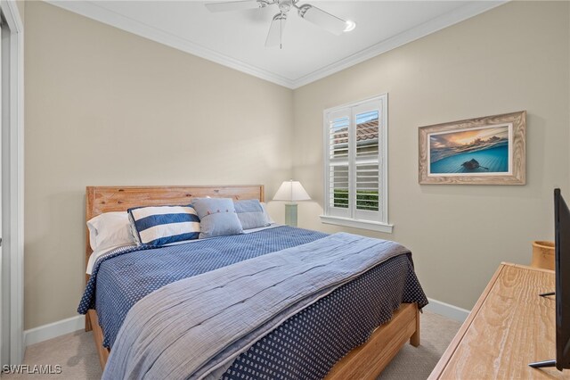 carpeted bedroom featuring ceiling fan and crown molding