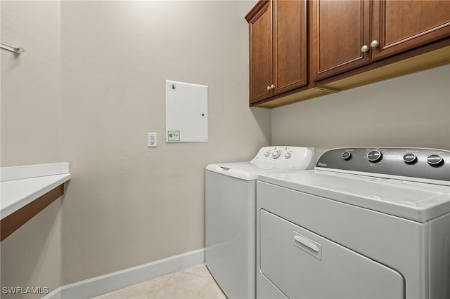 washroom with cabinets, separate washer and dryer, and light tile patterned floors