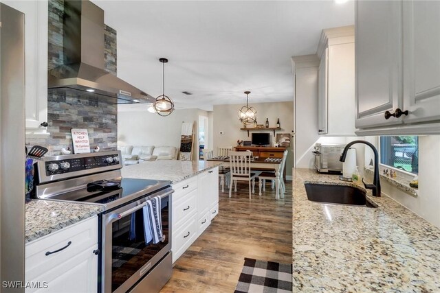 2600 Poinciana St, Naples, FL 34105 - kitchen featuring stainless steel range with electric cooktop, wall chimney range hood, a sink, and healthy amount of natural light
