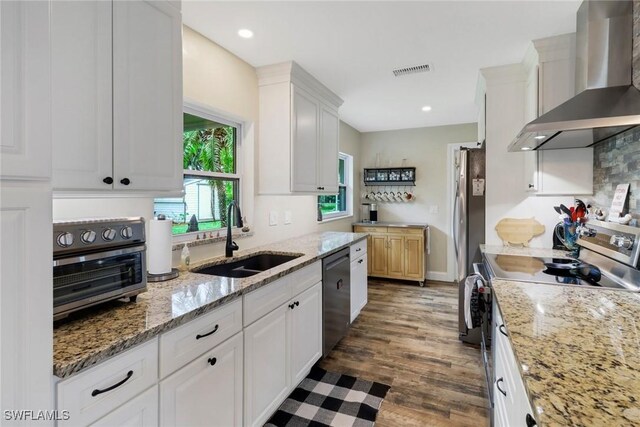 2600 Poinciana St, Naples, FL 34105 - kitchen with wall chimney exhaust hood, a sink, appliances with stainless steel finishes, white cabinets, and dark wood finished floors