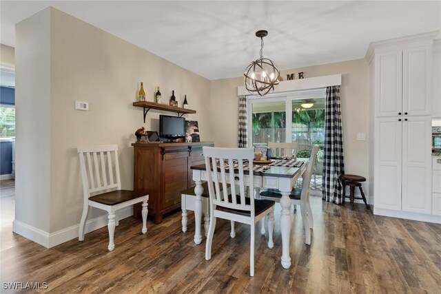 dining area featuring a chandelier, dark wood-type flooring, and a healthy amount of sunlight