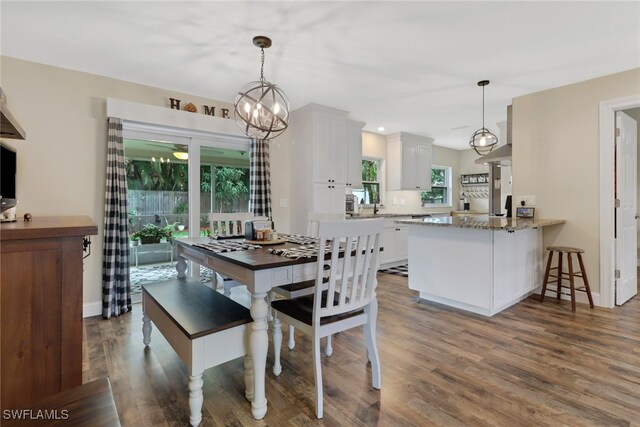 dining area featuring sink, dark hardwood / wood-style flooring, and an inviting chandelier