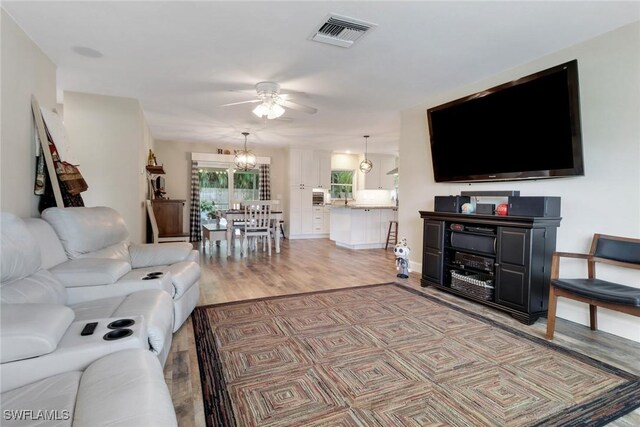 living room featuring hardwood / wood-style floors and ceiling fan with notable chandelier