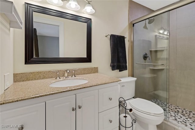 bathroom with vanity, a shower with shower door, and toilet