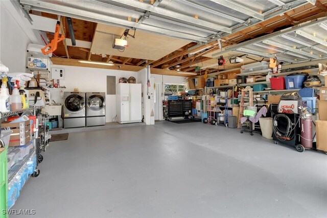 garage with washing machine and dryer and white refrigerator with ice dispenser