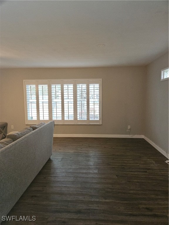 living room with plenty of natural light and dark wood-type flooring