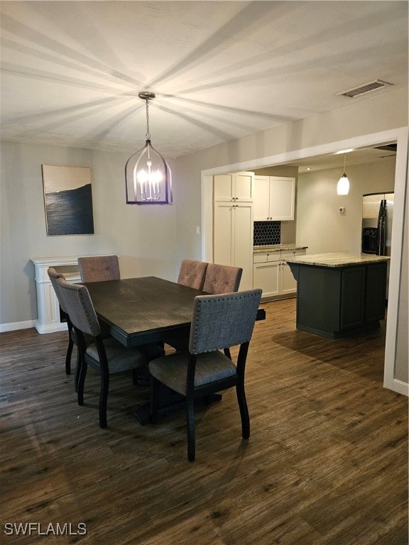 dining area featuring dark hardwood / wood-style flooring and an inviting chandelier