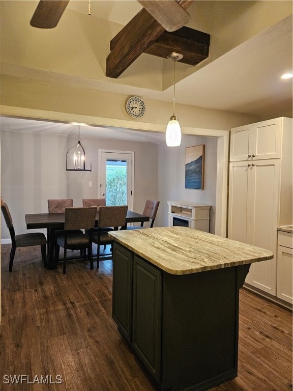 kitchen with decorative light fixtures, a kitchen island, white cabinetry, and dark wood-type flooring