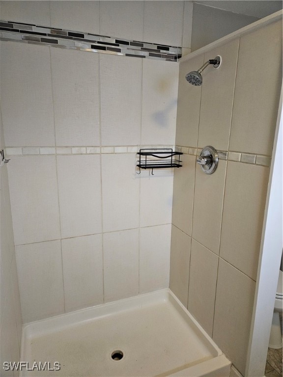 bathroom with toilet and a tile shower