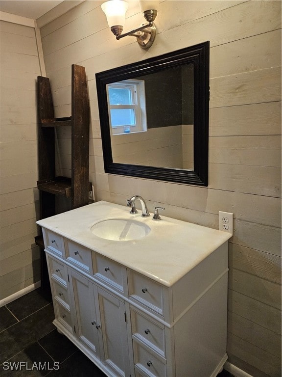 bathroom with tile patterned flooring, vanity, and wood walls