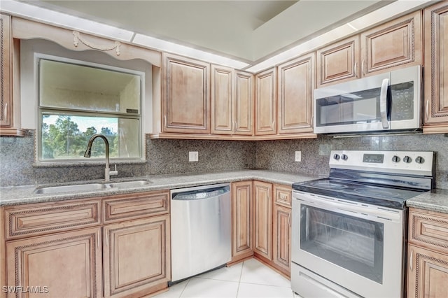 kitchen featuring sink, light stone counters, backsplash, light tile patterned floors, and appliances with stainless steel finishes