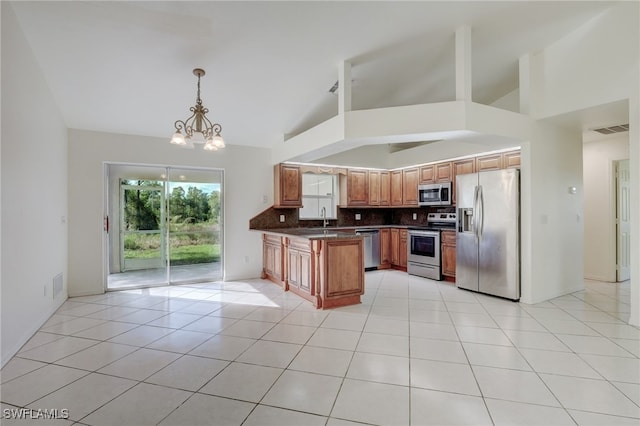 kitchen with pendant lighting, high vaulted ceiling, appliances with stainless steel finishes, a notable chandelier, and kitchen peninsula