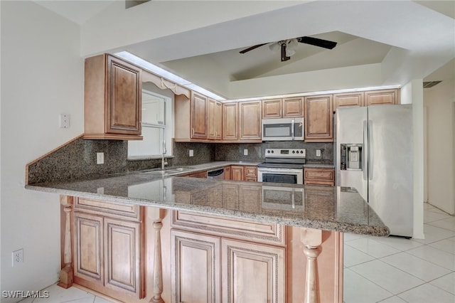 kitchen with tasteful backsplash, kitchen peninsula, lofted ceiling, light tile patterned flooring, and appliances with stainless steel finishes