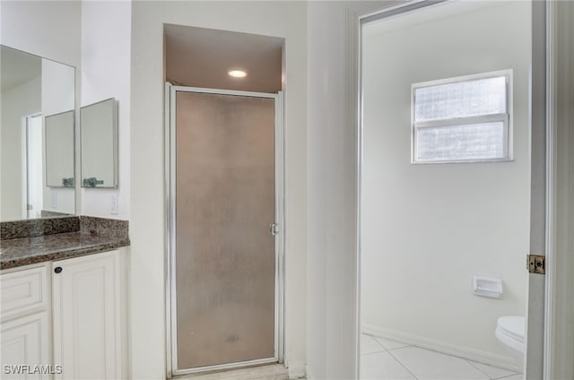 bathroom with tile patterned flooring, vanity, toilet, and walk in shower