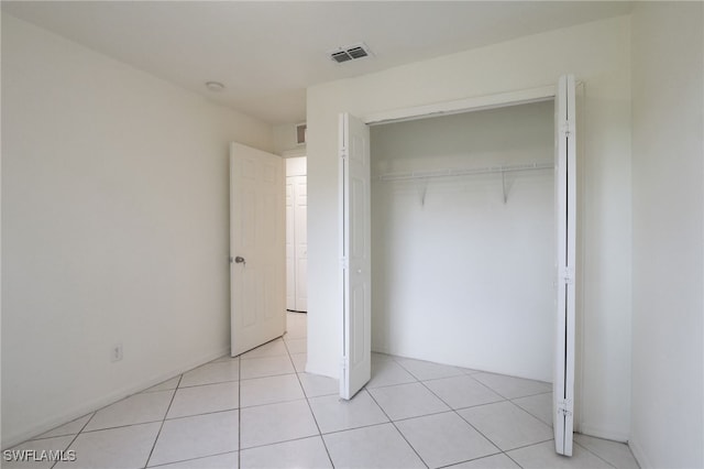 unfurnished bedroom featuring light tile patterned floors and a closet