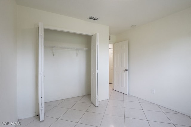 unfurnished bedroom featuring light tile patterned flooring and a closet