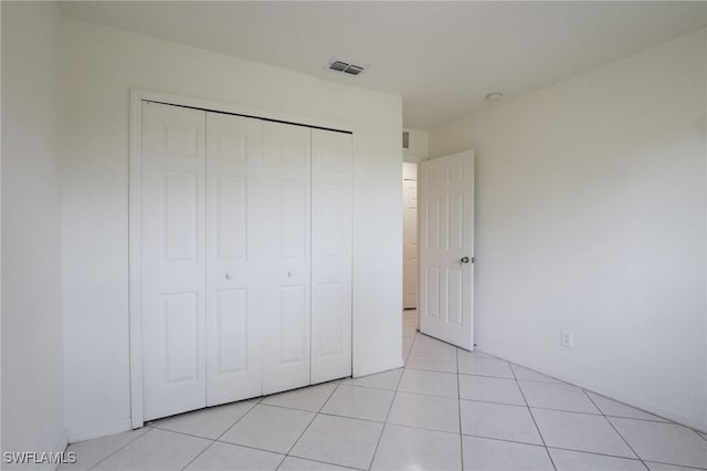 unfurnished bedroom with a closet and light tile patterned flooring