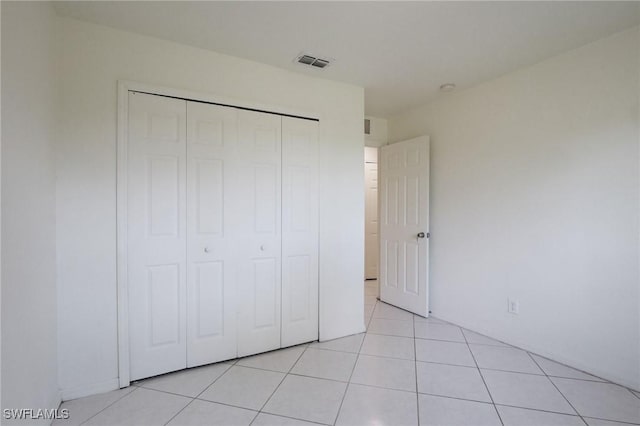 934 Garnet Ave, Lehigh Acres, FL 33974 - unfurnished bedroom with a closet and light tile patterned flooring