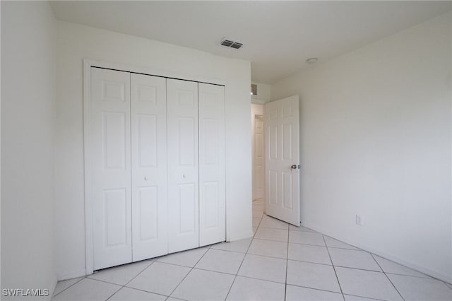 unfurnished bedroom with light tile patterned floors and a closet