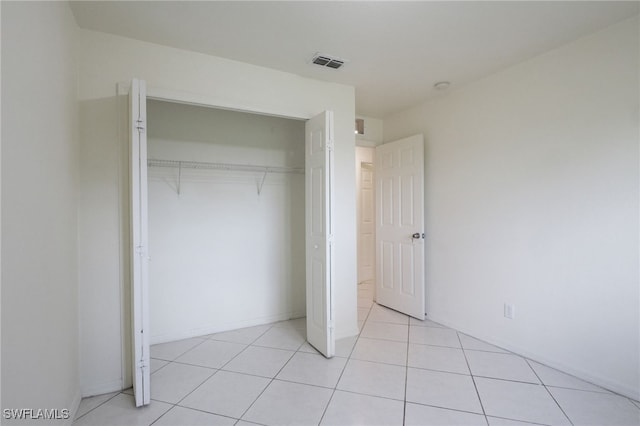 unfurnished bedroom with a closet and light tile patterned flooring