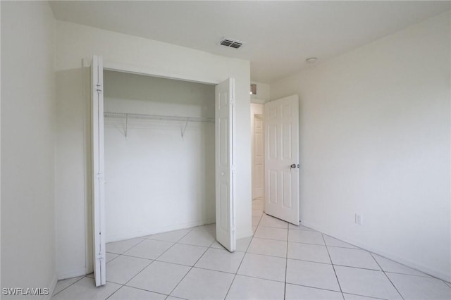 934 Garnet Ave, Lehigh Acres, FL 33974 - unfurnished bedroom with a closet and light tile patterned floors
