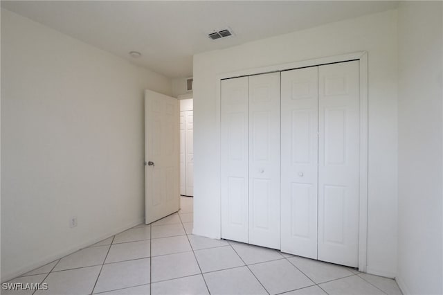 unfurnished bedroom with a closet and light tile patterned flooring