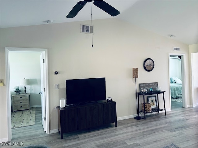 living room with ceiling fan, vaulted ceiling, and light hardwood / wood-style flooring