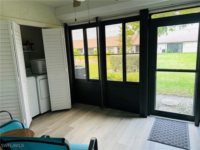 doorway to outside featuring washing machine and dryer and light hardwood / wood-style floors