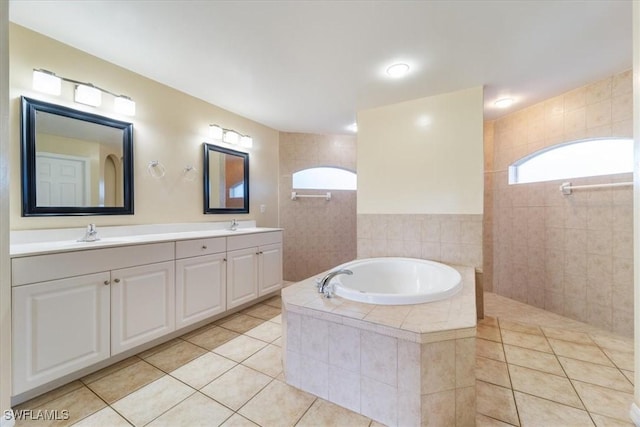 bathroom with tile patterned floors, vanity, independent shower and bath, and tile walls