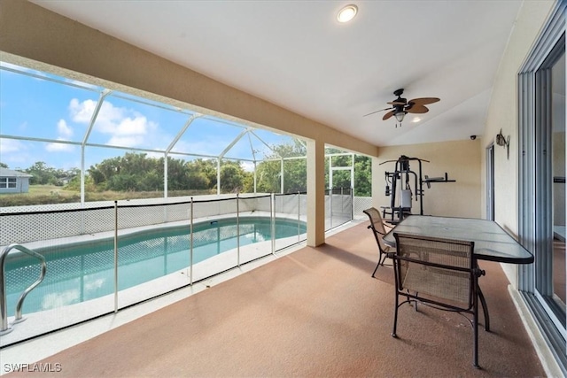 view of pool featuring glass enclosure, ceiling fan, and a patio