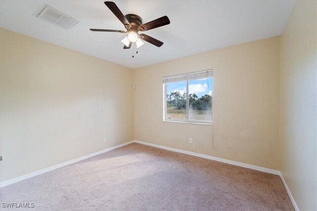 carpeted spare room featuring ceiling fan