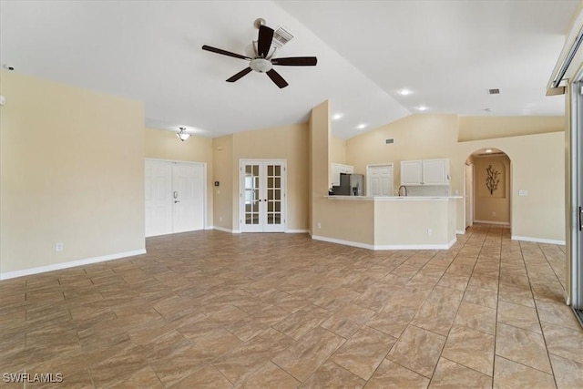 unfurnished living room with french doors, vaulted ceiling, and ceiling fan