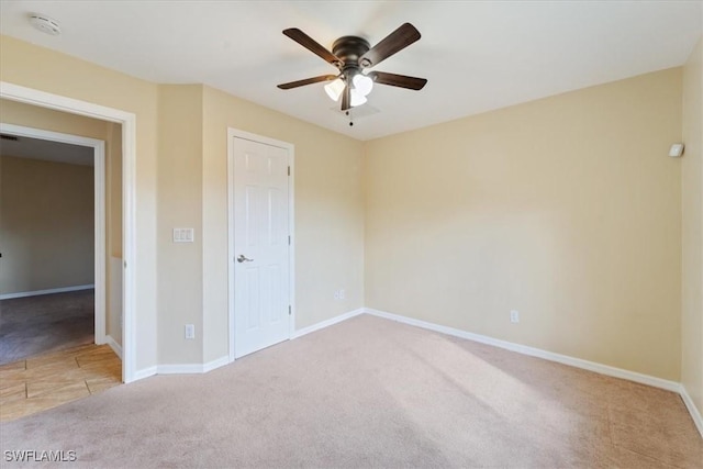 unfurnished bedroom featuring ceiling fan, a closet, and light colored carpet