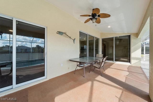 view of patio featuring ceiling fan and glass enclosure