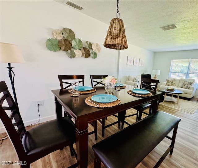 dining room featuring a textured ceiling and hardwood / wood-style flooring