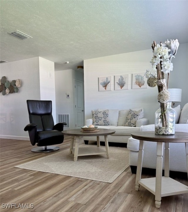 living room with hardwood / wood-style flooring and a textured ceiling