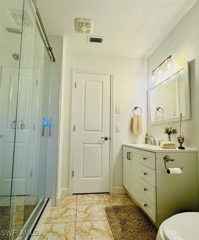 bathroom featuring a textured ceiling, vanity, toilet, and walk in shower